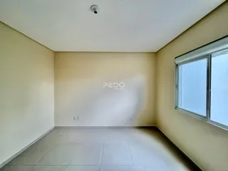 Ambiente interno de uma sala com piso de cerâmica e janela.