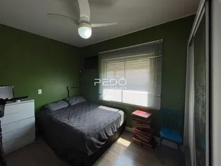 Quarto com cama e janela com persianas em sala.