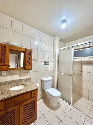 Foto de um banheiro com revestimento de cerâmica e louças sanitárias.