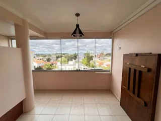 Sala de estar com grande janela que oferece uma vista da paisagem externa.
