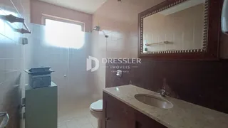 Banheiro com revestimento cerâmico e espelho.