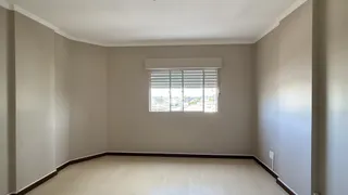 Ambiente interno de uma sala com piso de madeira clara e janela.