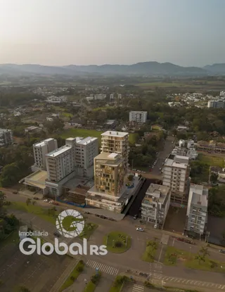Vista aérea de um bairro residencial em Lajeado, Brasil, mostrando edifícios e áreas verdes.