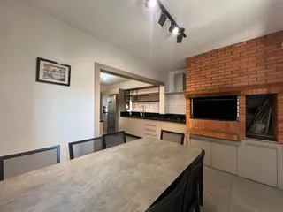 Interior de uma sala de estar com parede de tijolos aparentes e bancada de granito.