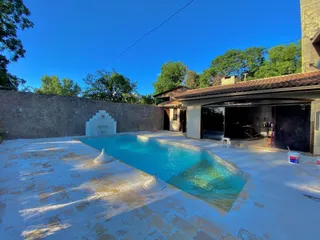 Foto de uma piscina externa com deck e área de lazer em uma propriedade.