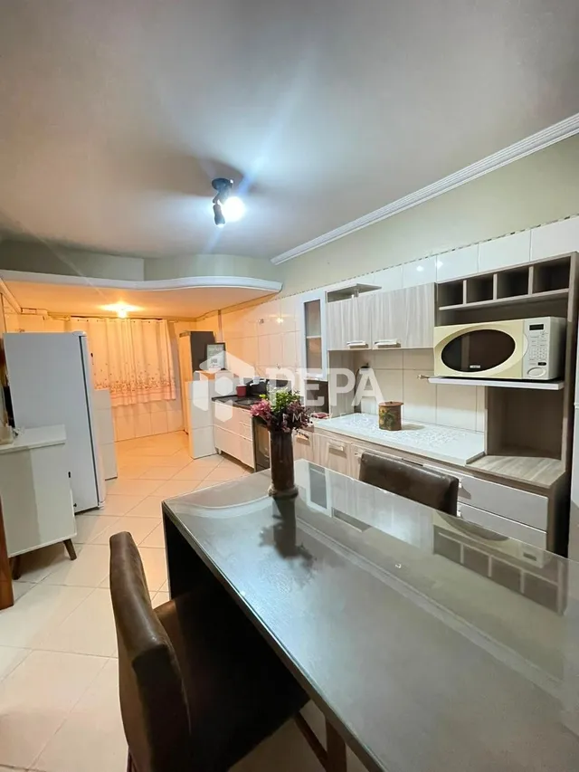 Foto de uma cozinha com armários brancos e bancada clara.