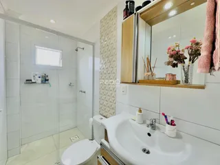 Foto de um banheiro moderno com box de vidro e louças brancas.