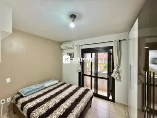 Quarto com cama e janela de acesso a uma porta externa.