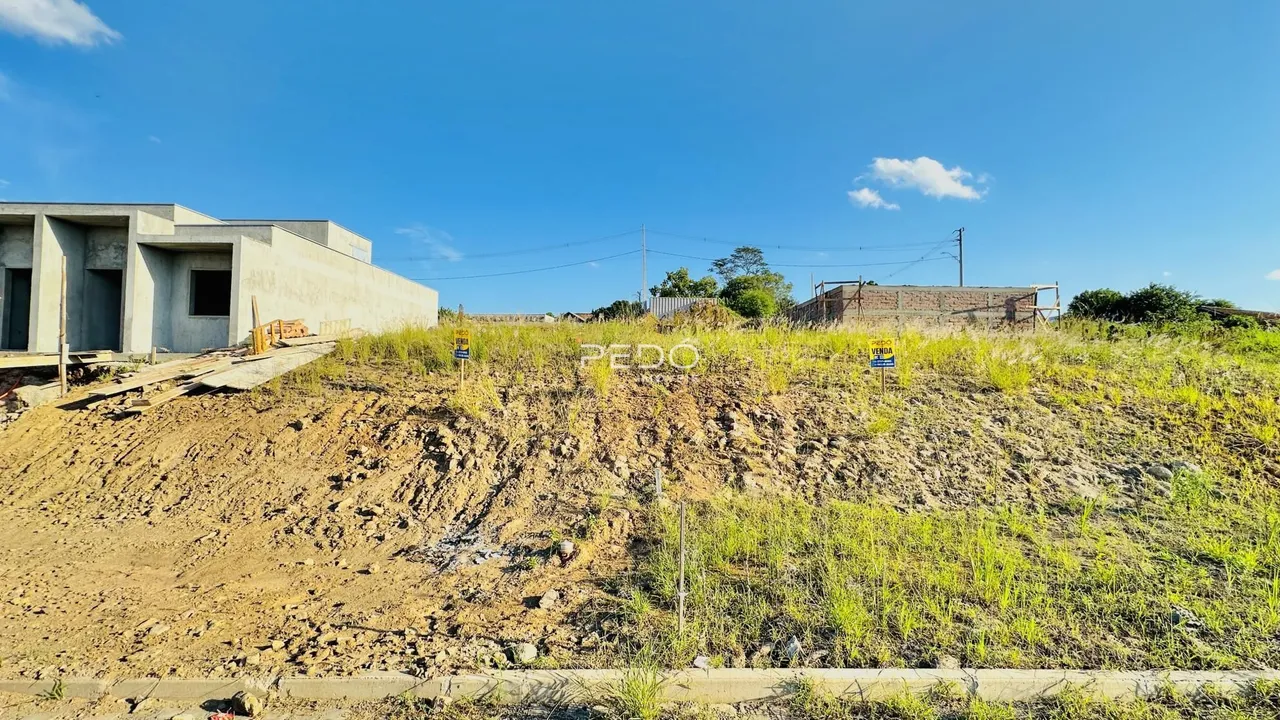 Vista externa de uma construção em terreno com vegetação rasteira.