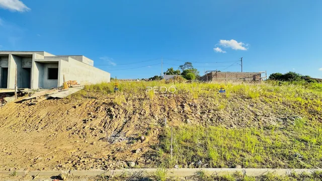 Vista externa de uma construção em terreno com vegetação rasteira.