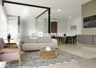Sala de estar moderna com sofá cinza e tapete preto e branco.