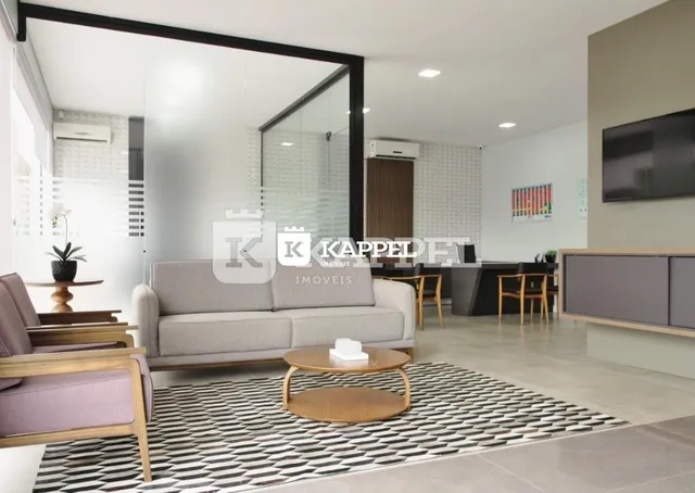 Sala de estar moderna com sofá cinza e tapete preto e branco.