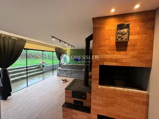 Sala de estar com piso de madeira e parede de tijolos com lareira.