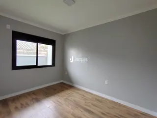 Foto de um cômodo interno com piso de madeira e janela.