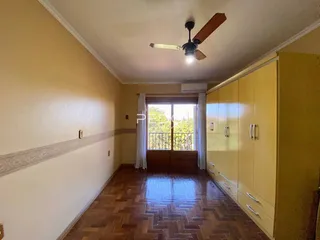 Vista de um corredor interno com piso de madeira e armários embutidos.
