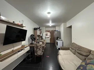 Ambiente interno de uma sala de estar com área de jantar e cozinha.