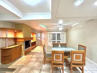 Interior de uma sala de estar com lareira e piso de cerâmica.