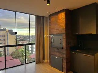 Sala com grande janela oferecendo vista da paisagem urbana.