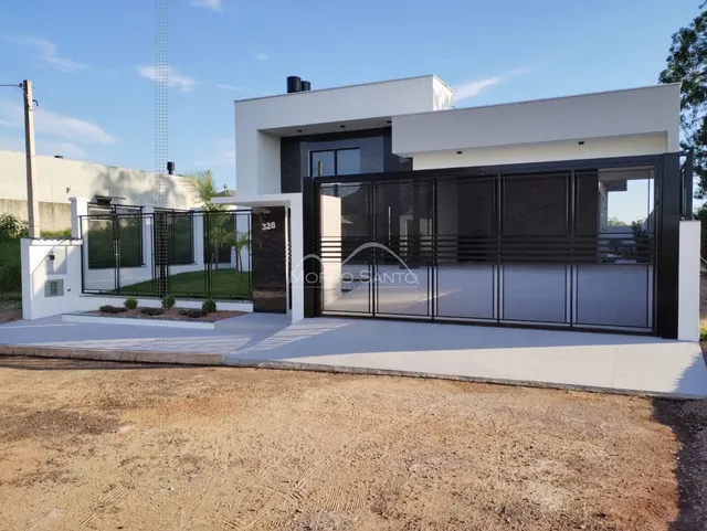 Fachada moderna de uma residência com muro e portão preto em Lajeado, Brasil.