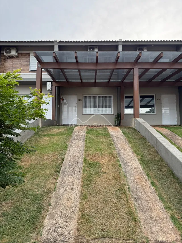 Foto da fachada de uma residência em Lajeado, Brasil, mostrando a entrada coberta e o jardim frontal.