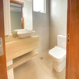 Foto interna de um banheiro com bancada e vaso sanitário.