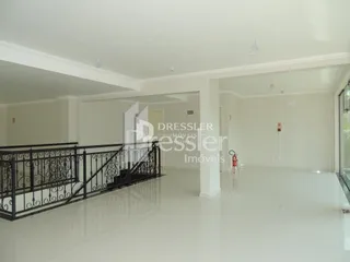 Ambiente interno amplo com paredes brancas e piso reflexivo.