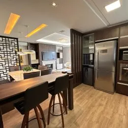 Foto de uma sala de jantar com mesa de madeira escura e cadeiras.