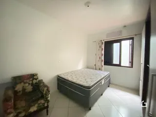 Quarto com cama e sofá em ambiente claro.