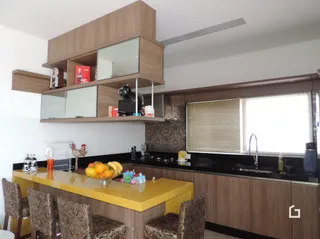 Ambiente interno com móveis de madeira e bancada na sala.