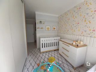 Quarto com cabeceira e cômoda brancos.