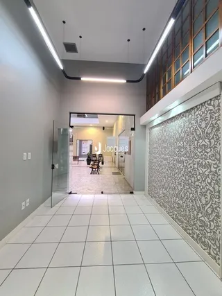 Corredor interno com piso de cerâmica e paredes brancas.