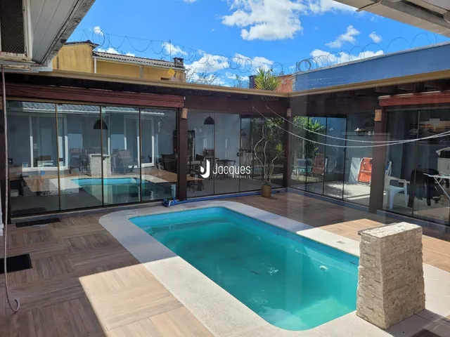 Foto de uma piscina externa com deck de madeira em uma residência.
