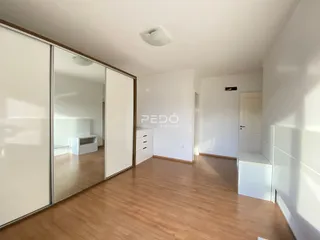 Vista interna de um ambiente com piso de madeira clara.