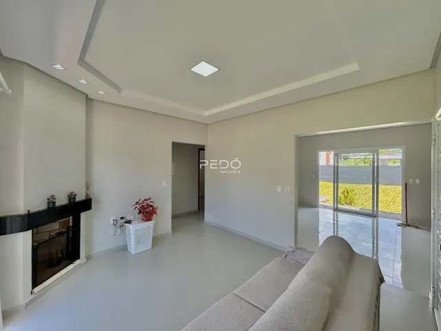 Sala de estar moderna com lareira e piso de cerâmica clara.