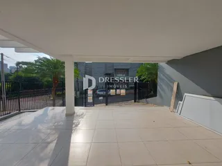 Área externa coberta com piso de cerâmica e grade de segurança.