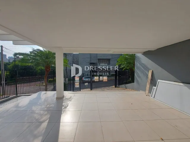 Área externa coberta com piso de cerâmica e grade de segurança.