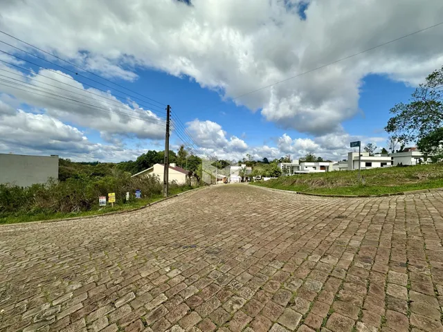 Vista da entrada de uma propriedade em Lajeado, Brasil, com pavimentação de paralelepípedos.