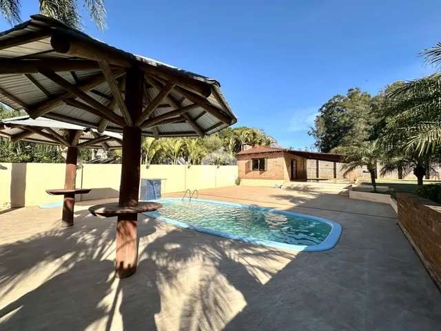 Vista de uma área externa com piscina e estrutura de madeira.