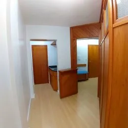 Hall de passagem com portas de madeira clara.