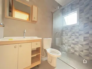Foto de um banheiro com bancada e box de vidro.