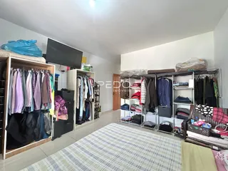 Quarto com guarda-roupas e roupas penduradas em um ambiente interno.