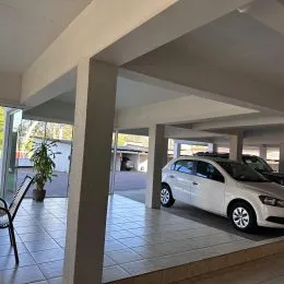Vista de um espaço interno com colunas e piso de cerâmica.