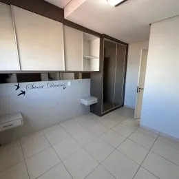 Ambiente interno com piso de cerâmica e armários brancos.