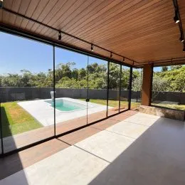 Vista de uma área externa com piscina e grade de vidro em uma propriedade em Lajeado.