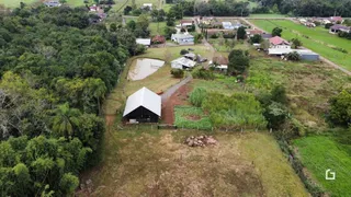 Vista aérea de uma propriedade rural em Lajeado, Brasil, mostrando áreas de vegetação e construções.
