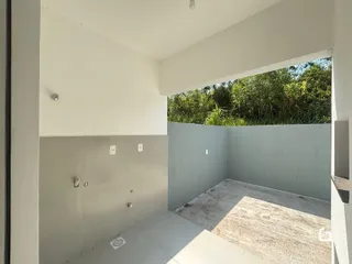 Vista interna de uma área com paredes brancas e piso claro.