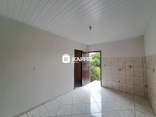 Corredor interno com piso de porcelanato claro e acesso a uma área externa.
