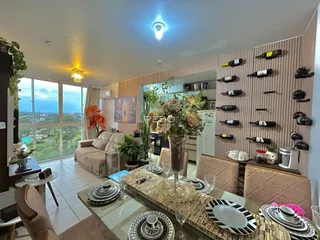 Sala de estar com vista para o mar e decoração de vinhos na parede.