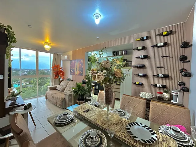 Sala de estar com vista para o mar e decoração de vinhos na parede.