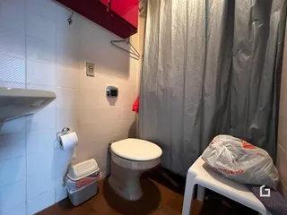 Foto de um banheiro com azulejos brancos e vaso sanitário.